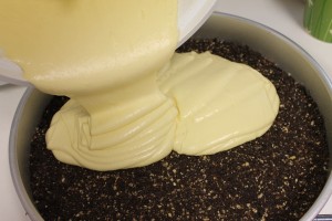Pouring cake batter over the chocolate crust.